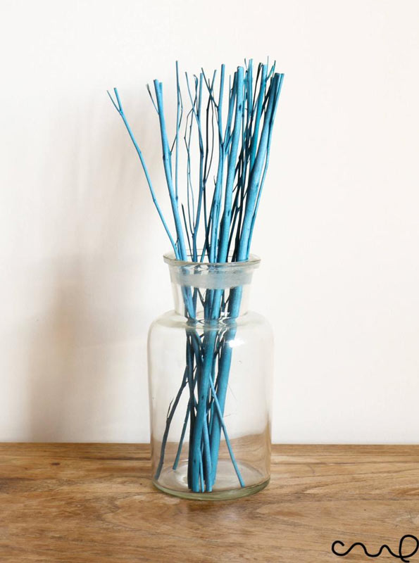 Vaso trasparente con rami dipinti in colore blu.