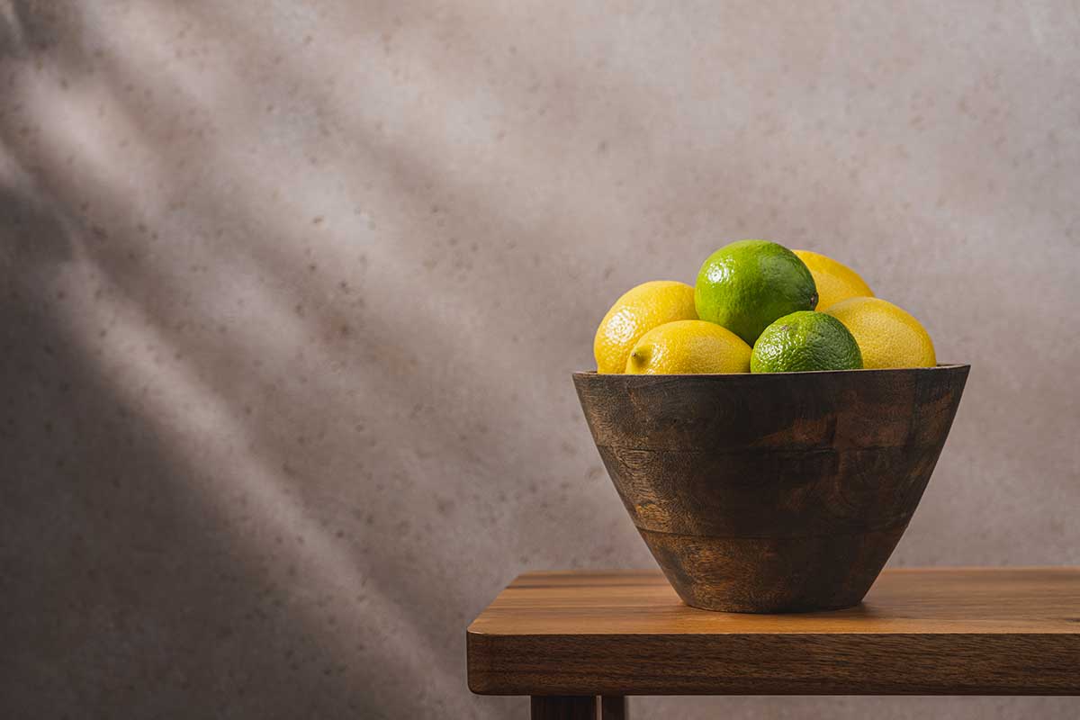 limoni gialli e verdi in un vaso su un tavolo